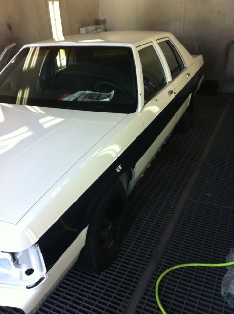 1991 Ford LTD Crown Victoria - A white and black Ford Crown Victoria is being worked on in a paint booth.