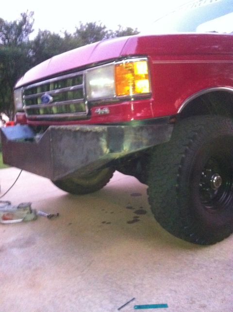 1989 Ford Bronco - Custom steel bumper installed on a red Ford truck, likely from the late 1980s.