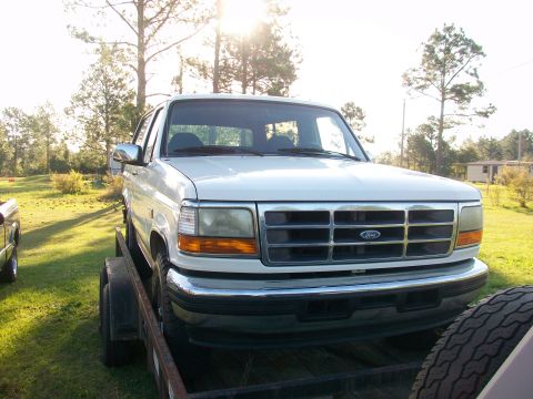 1995 Ford Bronco - A white Ford Bronco is parked on a trailer, viewed from the front.