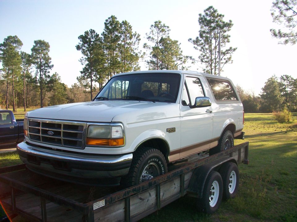 White 1995 Ford Bronco on a trailer, 3/4 front view