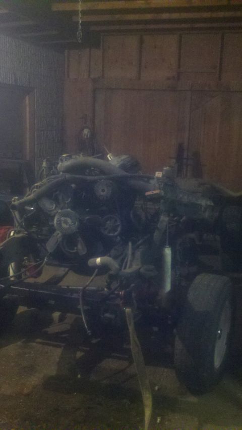 1988 Ford Bronco - The engine and chassis of a vehicle are visible, with parts removed and the vehicle in a state of disassembly.