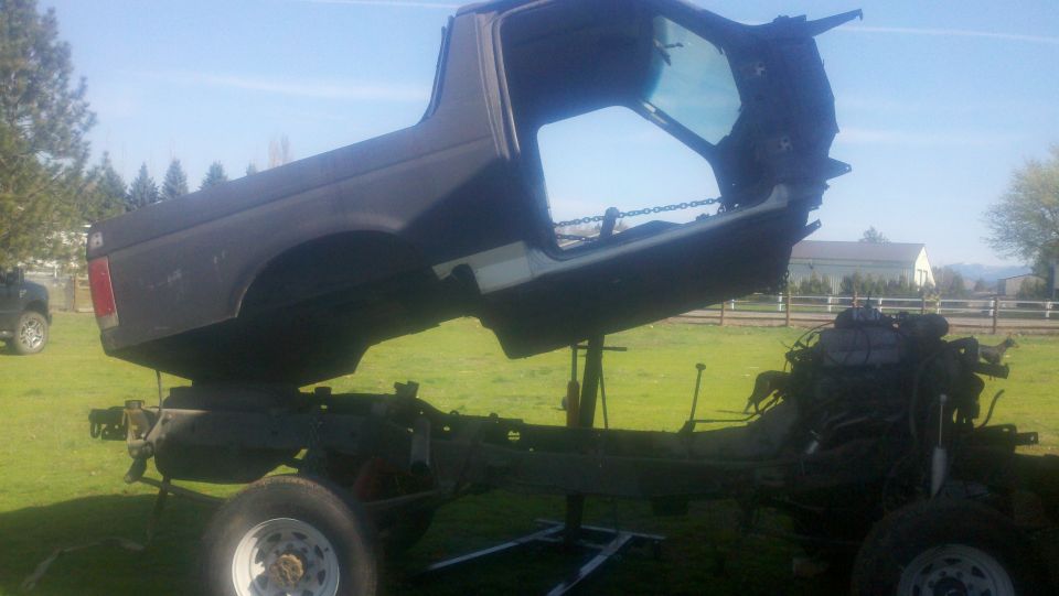 Disassembled 1988 Ford Bronco body and chassis on grass