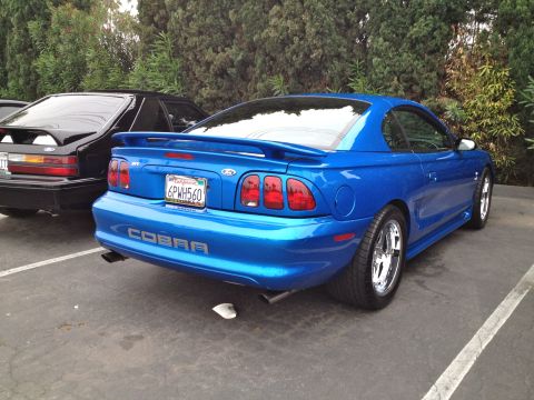 2004 Ford Crown Victoria - Rear view of a blue 1996 Ford Mustang Cobra with a California license plate.