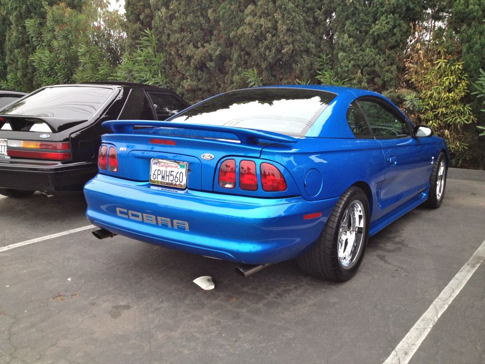 Blue Ford Mustang Cobra parked next to a black car