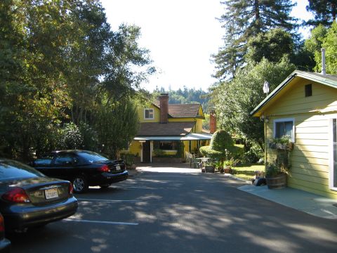 2002 Ford Taurus - A black sedan is parked in a driveway with a yellow house in the background. The license plate reads LZY097.