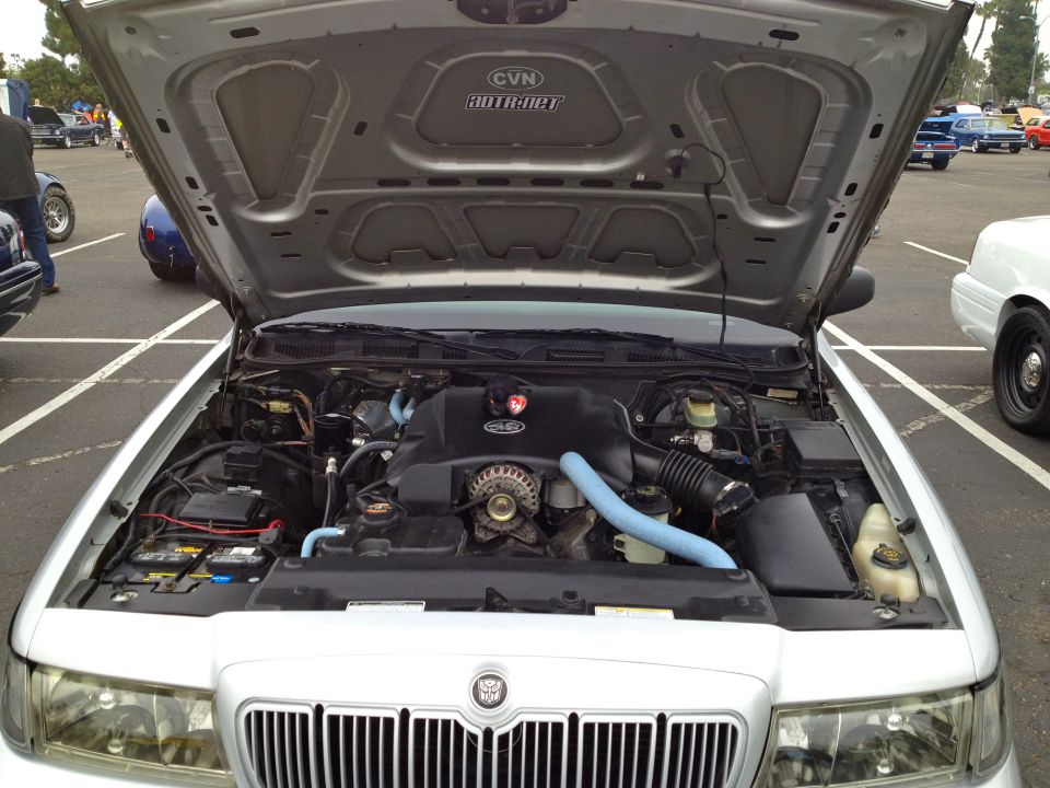 2004 Ford Crown Victoria engine bay with hood open, showing V8 engine and parts