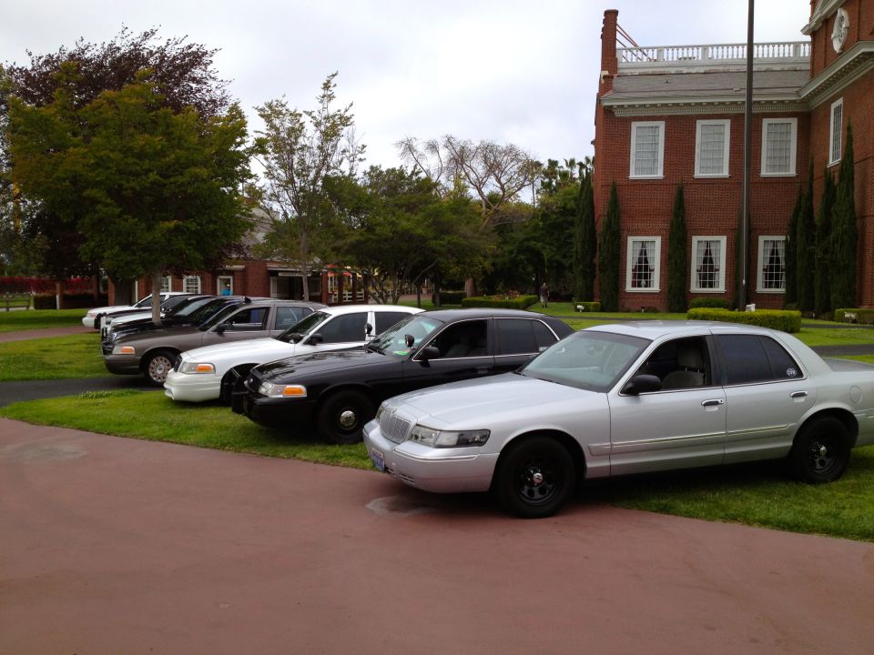 Silver 2004 Ford Crown Victoria and several other Crown Victorias parked in a line