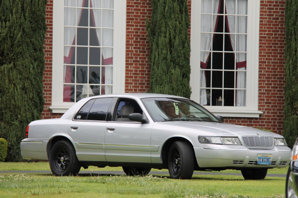 Silver 2004 Ford Crown Victoria with black wheels and a license plate reading 'DENGONG'