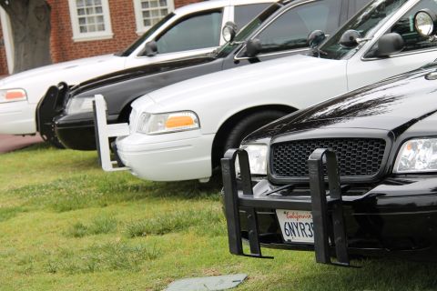 2004 Ford Crown Victoria - Multiple Ford Crown Victoria police cars are parked in a line on a grassy area.