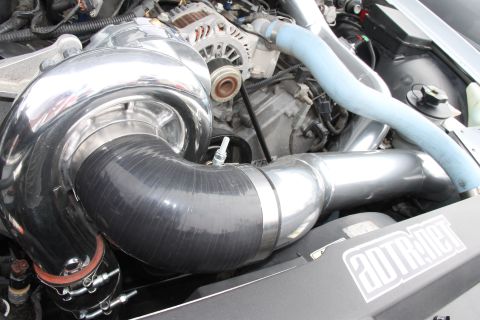 2004 Ford Crown Victoria - Close-up of a modified engine bay a prominent turbocharger and custom piping.
