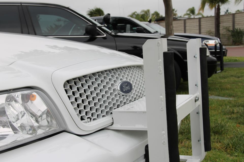 White 2004 Ford Crown Victoria with push bumper and honeycomb grille