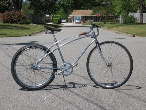 1994 Ford Bronco - A shiny chrome cruiser bicycle with a classic design is parked on a suburban street.