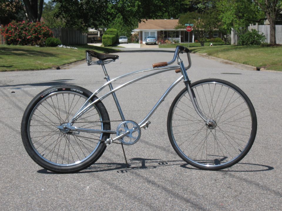 Chrome cruiser bicycle with black tires and brown leather seat