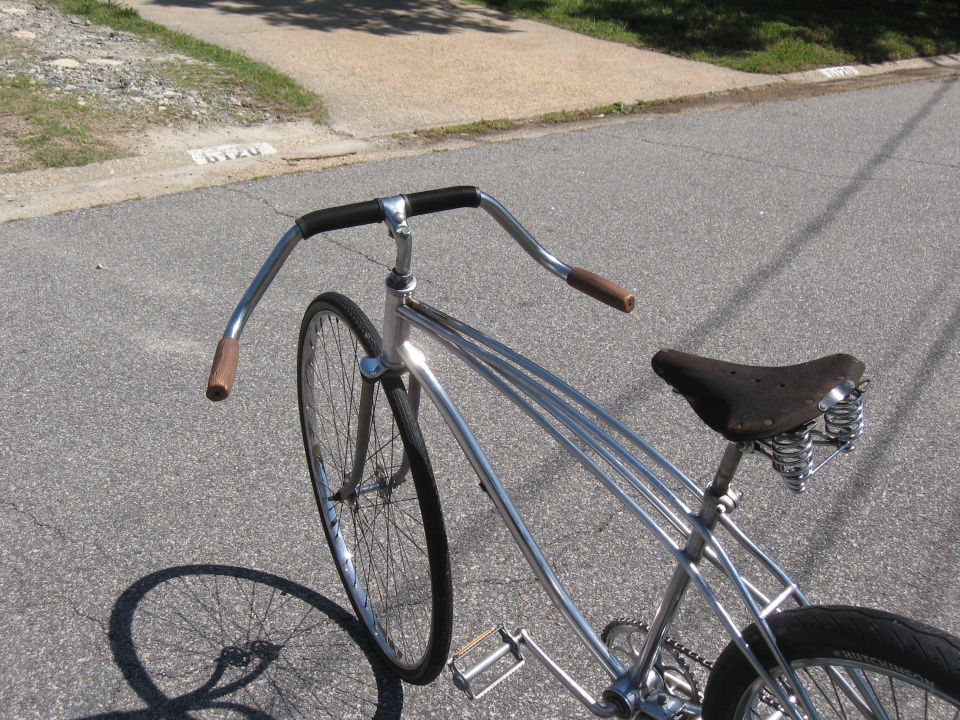 Chrome frame bicycle with brown leather sprung seat and swept handlebars