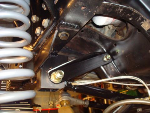1995 Ford Bronco - Undercarriage view of suspension components, including a large coil spring and linkage system.