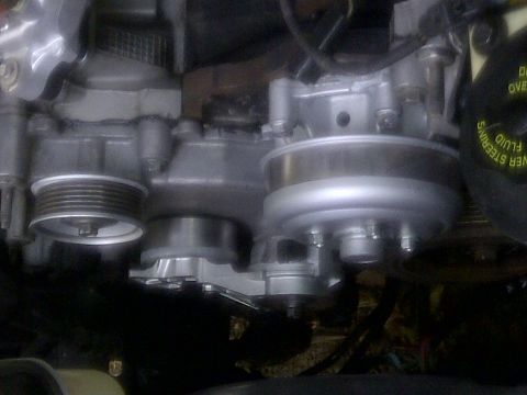 2000 Ford Crown Victoria - Close-up view of engine pulleys and associated components, including a power steering fluid cap.