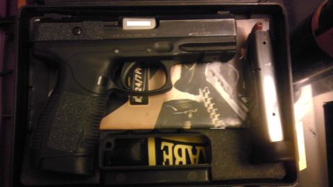 2000 Mercury Grand Marquis - A pistol is shown inside its case, alongside a magazine and some documentation.