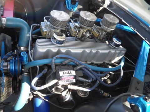 1994 Jeep Cherokee - Close-up of a modified V8 engine triple carburetors and custom blue hoses.