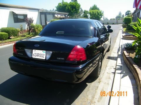 2003 Ford Crown Victoria - Rear view of a black 2003 Ford Crown Victoria parked on a sunny day.