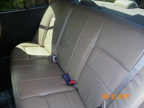 2003 Ford Crown Victoria - Smooth tan leather rear seating with stitched panels and two latched seatbelt buckles