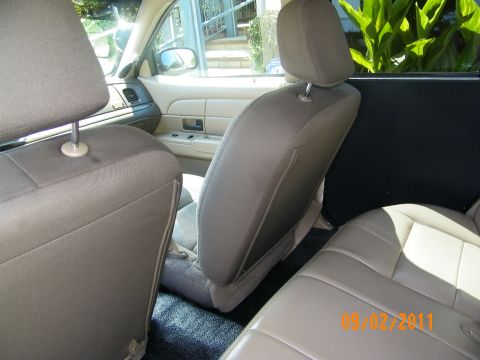 2003 Ford Crown Victoria - Interior angle from rear footwell showing front headrest, console and beige rear cushion