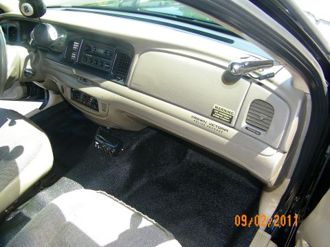 2003 Ford Crown Victoria - Dash and front interior showing radio stack, lower controls and Crown Victoria Police badge