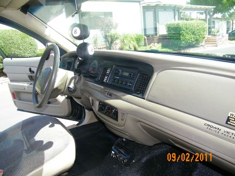 2003 Ford Crown Victoria - Interior toward passenger dash showing radio, auxiliary gauges, A-pillar spotlight and badge