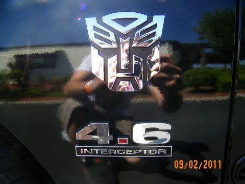 2003 Ford Crown Victoria - Polished Transformers emblem with photographer reflection sitting over a 4.6 Interceptor badge