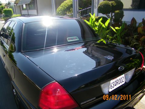 2003 Ford Crown Victoria - Trunk and taillight view of a black Crown Victoria with CA plate 6SQR002 and red taillamp.