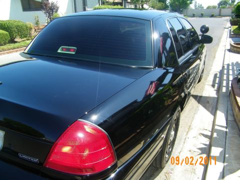 2003 Ford Crown Victoria - Rear three-quarter shot of a black Crown Victoria Limited parked in a driveway, taillight and trunk badge shown.