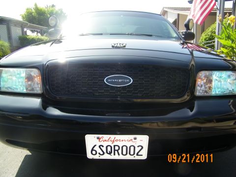 2003 Ford Crown Victoria - Close front view of a black Crown Victoria honeycomb grille with Interceptor emblem and CA plate 6SQR002.