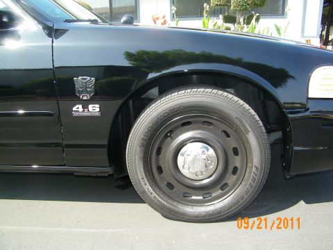 2003 Ford Crown Victoria - Black steel wheel and front fender of a Crown Victoria showing 4.6 Interceptor badge and Autobot decal.