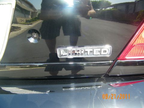 2003 Ford Crown Victoria - Close-up of the chrome Limited badge and Police Interceptor script on a black Crown Victoria trunk lid.