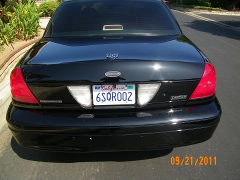 2003 Ford Crown Victoria - Straight rear view of a black Crown Victoria with twin taillights, CA plate 6SQR002 and Limited badge.