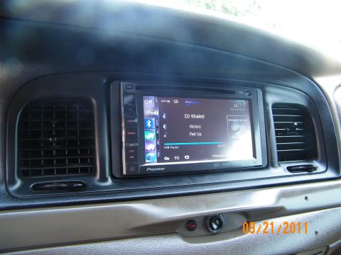 2003 Ford Crown Victoria - Dashboard mounted Pioneer screen playing audio track, vents on each side and control knob below