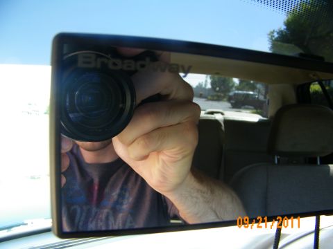 2003 Ford Crown Victoria - Aftermarket Broadway wide-angle mirror reflects photographer and tan rear seats inside vehicle