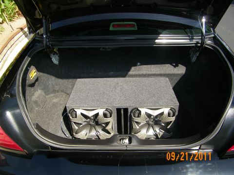 2003 Ford Crown Victoria - Vehicle trunk fitted with gray enclosure containing dual subwoofers, third brake light visible