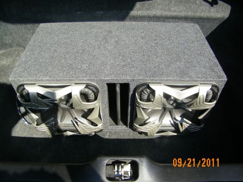 2003 Ford Crown Victoria - Dual subwoofer box in trunk showing two large drivers with ribbed surrounds in gray carpet