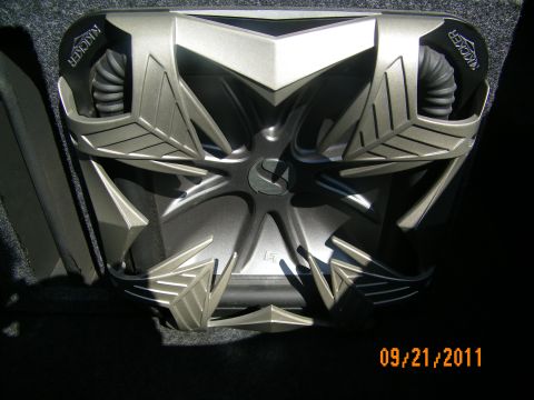 2003 Ford Crown Victoria - Single Kicker subwoofer driver detail showing silver star cone design and surround in enclosure