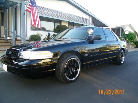 2003 Ford Crown Victoria - Front quarter of a black 4.6 Crown Victoria on machined-lip black wheels by a flag.