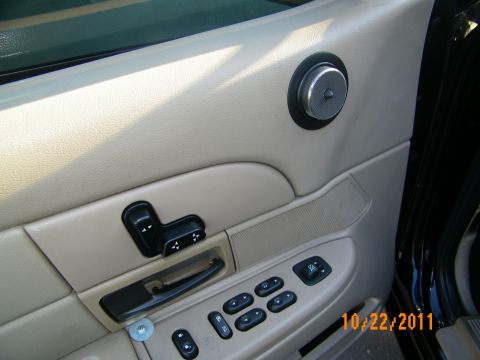 2003 Ford Crown Victoria - Beige driver door trim showing window, mirror and seat memory controls inside a black sedan