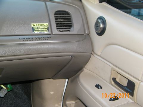 2003 Ford Crown Victoria - Glovebox area badged Crown Victoria Police Package beside a high-speed warning sticker