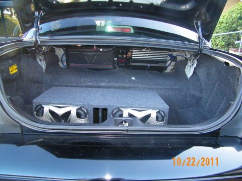 2003 Ford Crown Victoria - Open trunk showing a carpeted subwoofer enclosure and mounted amplifiers