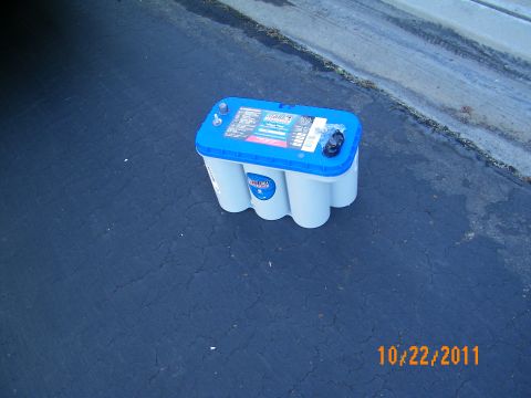 2003 Ford Crown Victoria - Blue-topped Optima AGM battery placed on the ground beside a curb