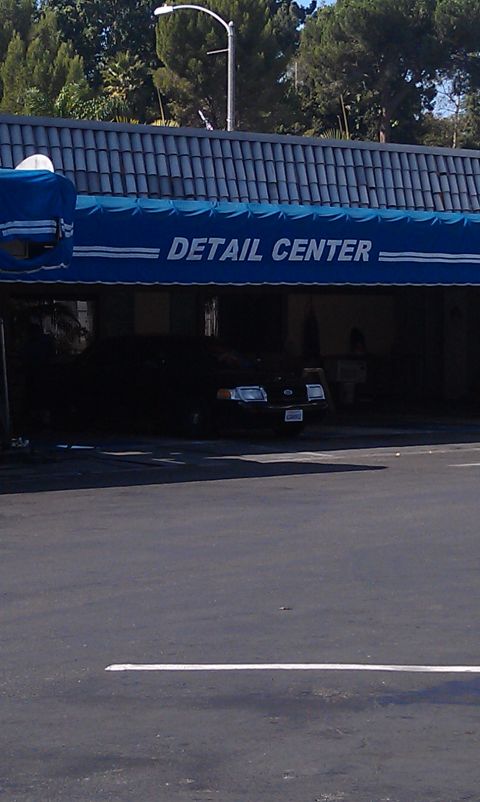 2003 Ford Crown Victoria - Blue-awning detail center bay sign with a vehicle parked in the shade