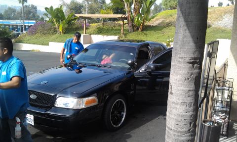 2003 Ford Crown Victoria - Front of a black Crown Victoria with Ford grille being detailed by attendants