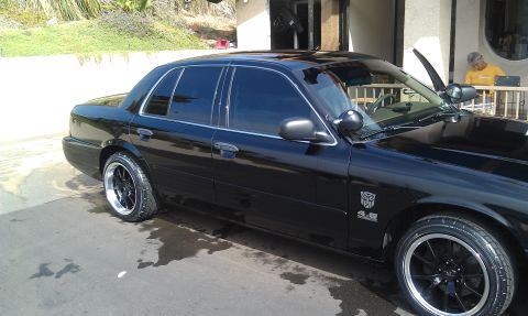 2003 Ford Crown Victoria - Side view of a blacked-out Crown Victoria sedan with tinted windows and 4.6 fender badge