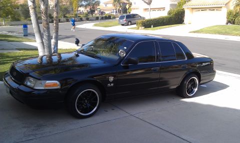 2003 Ford Crown Victoria - Crown Victoria sedan on a residential driveway, dark tint and lowered stance, 4.6 badge on fender