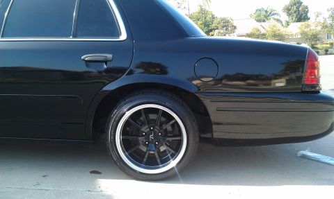 2003 Ford Crown Victoria - Close rear-quarter shot of a black Crown Victoria, fuel door and dark tinted glass visible