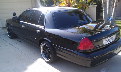 2003 Ford Crown Victoria - Rear view of a lowered black Crown Victoria parked by a garage, ADT sign in background